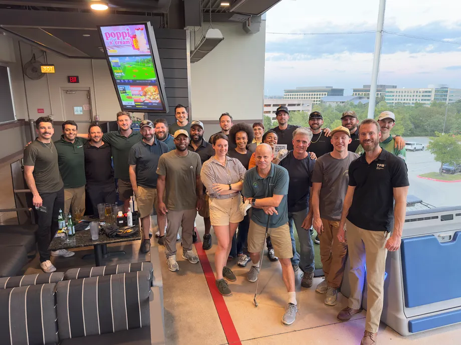 Handoff team and contractors gathered for a group photo at a Topgolf bay in Austin.